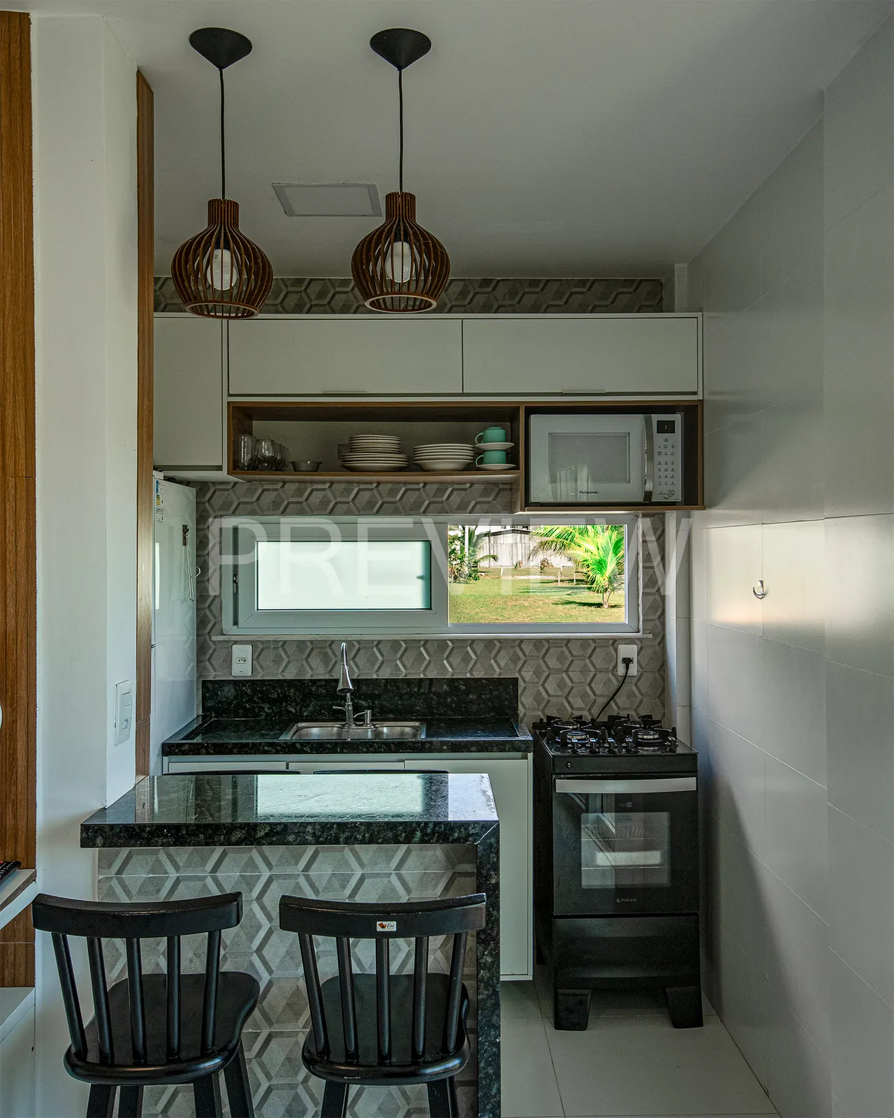 Cozinha americana equipada com fogão, micro-ondas, bancada de granito e pendentes de palha