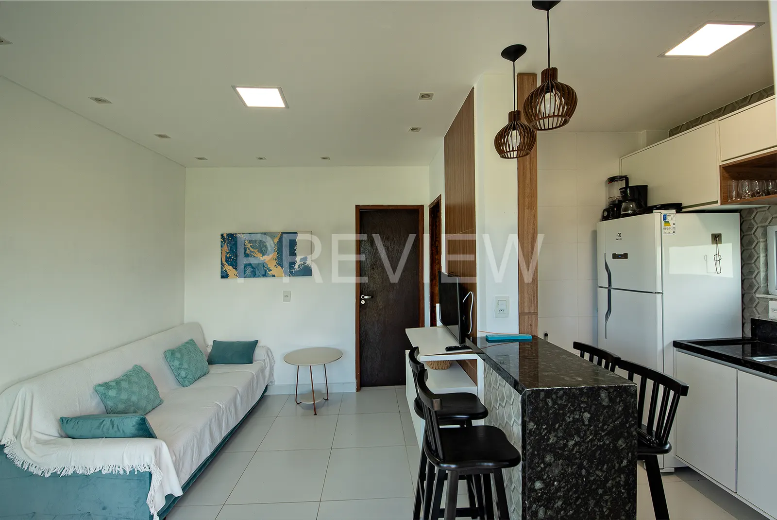 Sala com sofá e cozinha americana